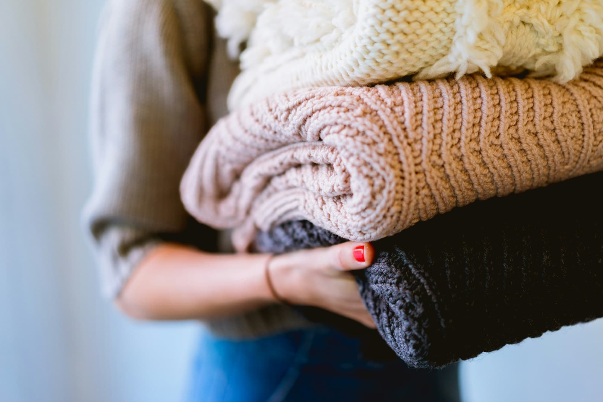 A warm stack of clean folded knitwear carried back to the door