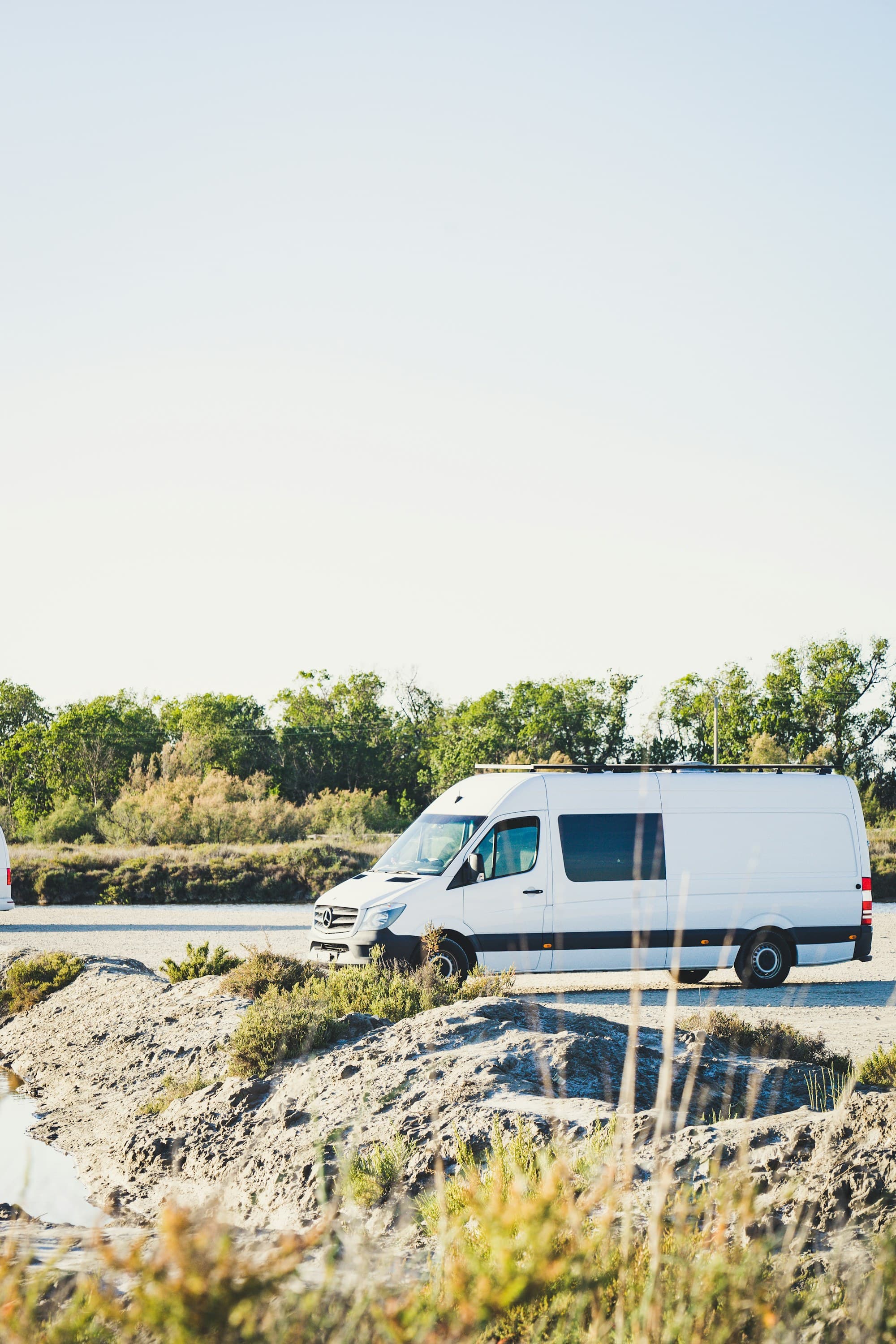 A white delivery van on the road under open sky