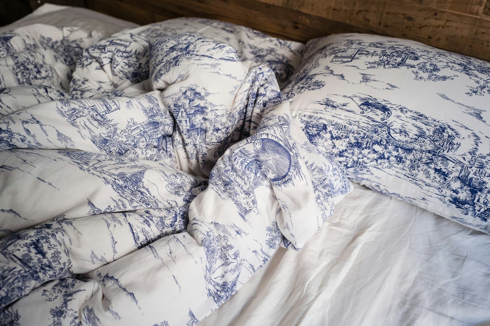 A made bed with a patterned comforter and pillows